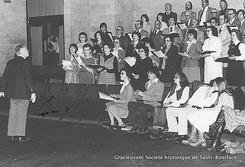 Années 1970 : le père Martial Caron dirige la Chorale des Intrépides dans la salle Pauline-Boutal du CCFM. En médaillon : le père Martial Caron, s.j.