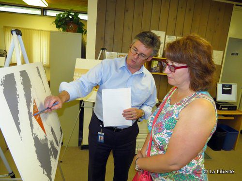 Le gérant des services bibliothécaires de la Ville de Winnipeg, Rick Walker, souligne un des éléments d’un dessin architectural de la future nouvelle bibliothèque du Parc Windsor à une résidente de Southdale, Cheryl Bennet
