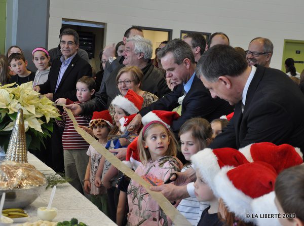 James Allum (au centre), le ministre de l’Éducation et de l’Enseignement supérieur du Manitoba coupe le ruban d'inauguration du nouveau gymnase de l'école communautaire de Saint-Georges.