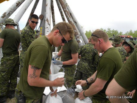 Des soldats d’Edmonton remplissent des sacs de sable à Saint-Laurent.