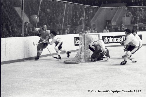 « Sur la glace », au stade Loujniki de Moscou, en 1972, lors de la célèbre « Série du siècle ». De gauche à droite, Alexandre Yakushev, hockeyeur soviétique; Guy Lapointe; Ken Dryden; Rodrigue Gilbert de Serge Savard. En médaillon : Serge Savard en 1972, arborant le chandail de l’équipe du Canada, lors de la « Série du siècle ».