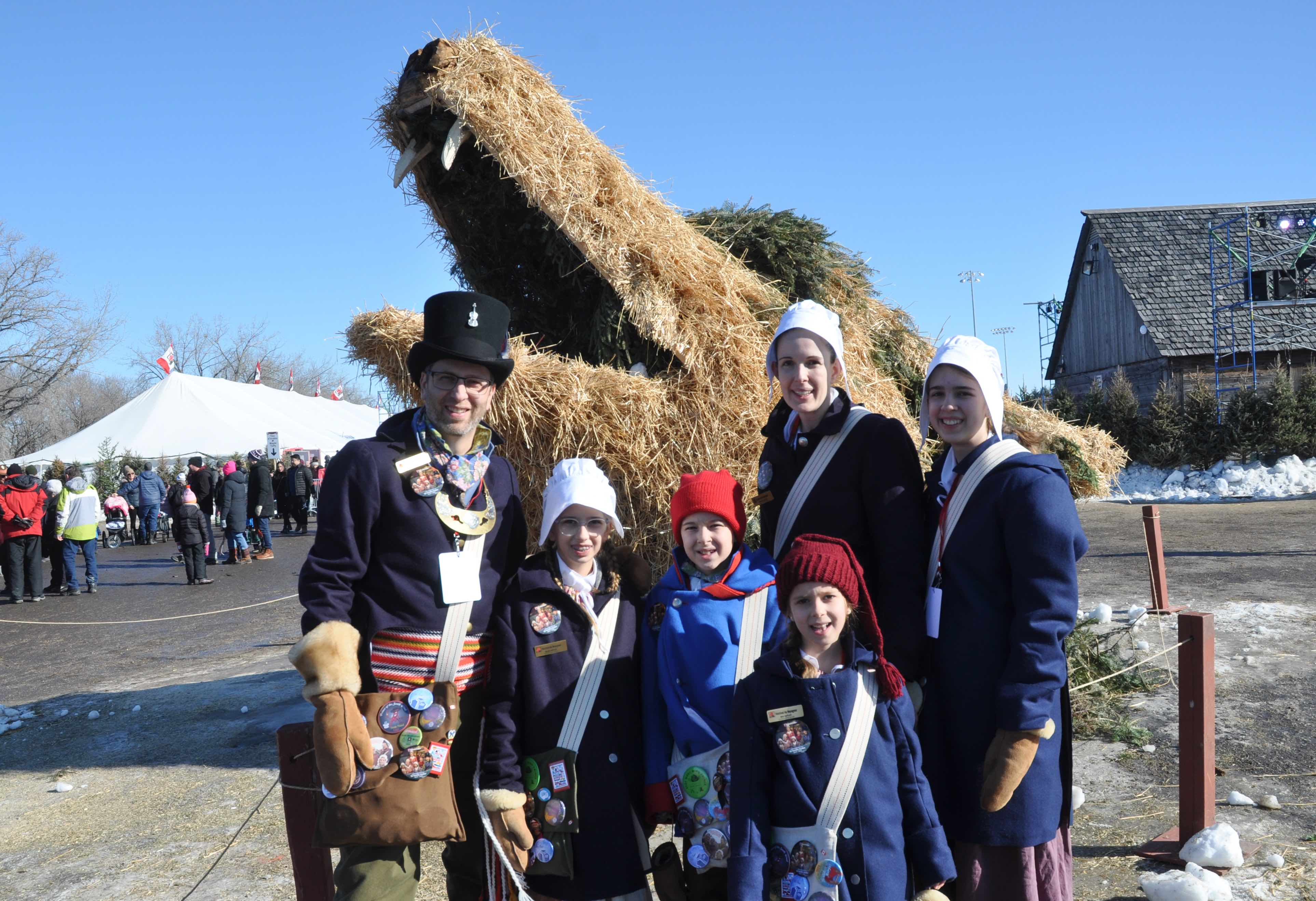 La famille des Voyageurs officiels devant une sculpture végétale de loup au parc du Voyageur. De gauche à droite : Philippe, Élise, Rémi, Mia (devant), Danièle et Danika Hutlet.