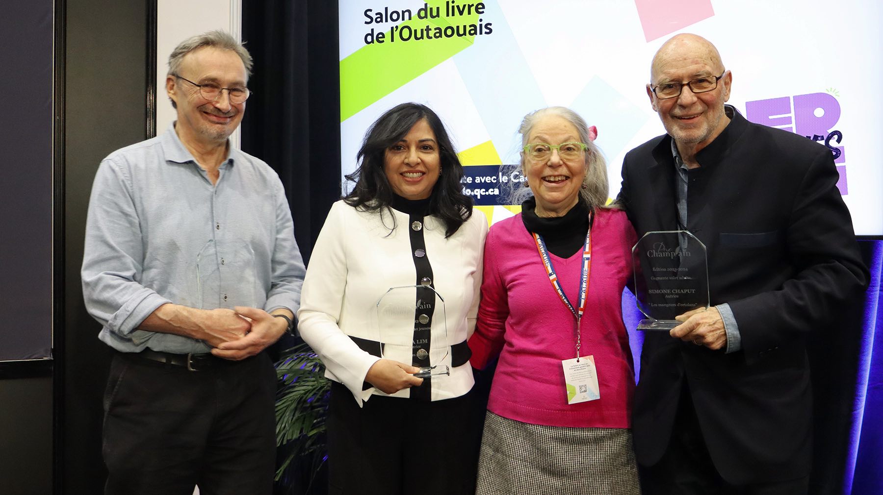 De gauche à droite : L’illustrateur Jean-Luc Trudel et l’autrice Diya Lim ont reçu le Prix Champlain pour le livre Éli Labaki et les gouttes de pluie. Ils sont en compagnie de leur éditrice Marie Cadieux ainsi que de Pierre Filion, éditeur de Simone Chaput, lauréate du volet adulte pour son roman Les mangeurs d’ortolans.