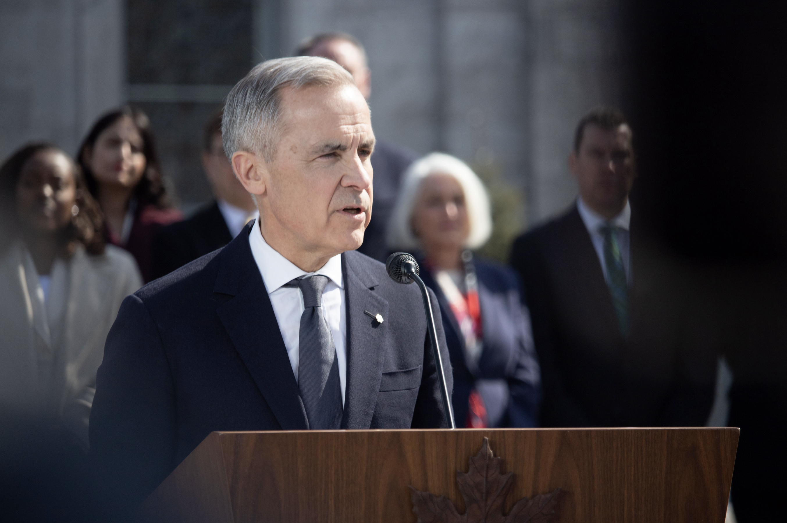 Mark Carney devant un podium.