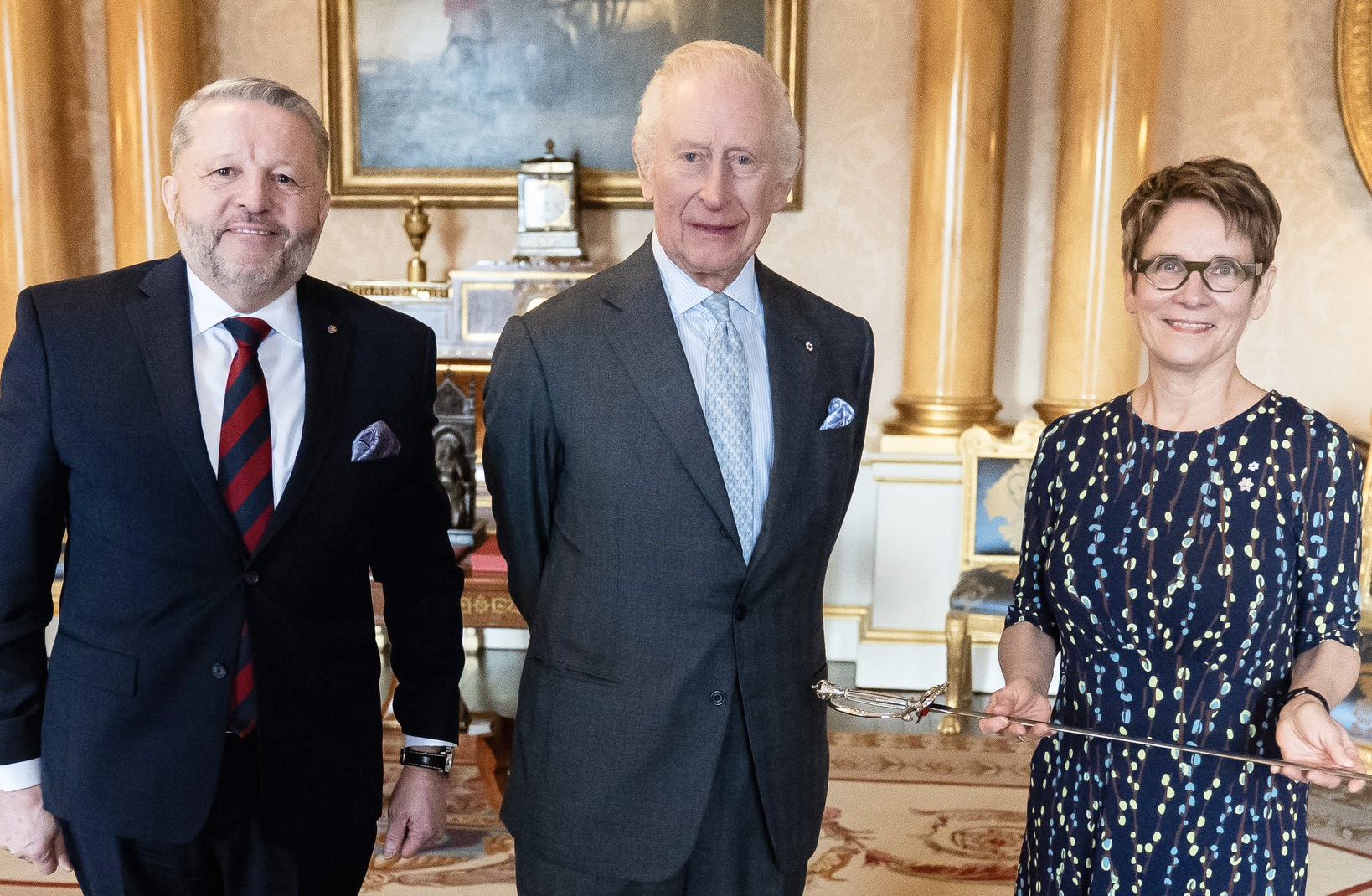 Raymonde Gagné aux côtés de l'huissier du bâton noir, J. Greg Peters, et de Sa Majesté le roi Charles III au palais de Buckingham.
