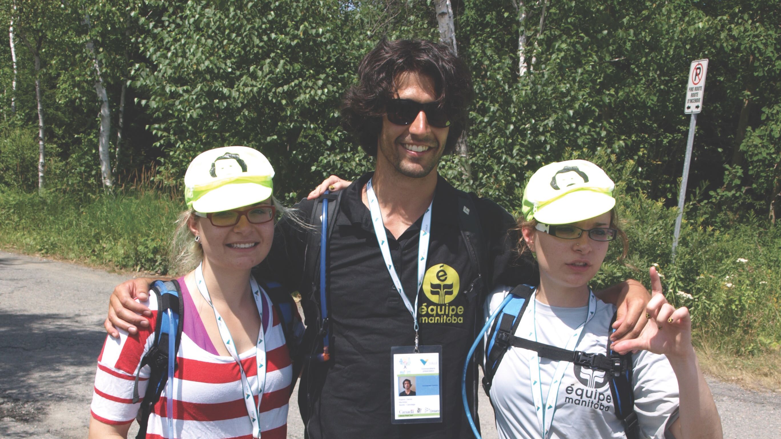 Souvenir des JeuxFC 2011, à Sudbury : Carine Roy (à gauche), sa sœur jumelle Josée (à droite) et leur entraineur de canot, Daniel Dupont. Carine et Josée Roy avaient gagné la médaille d’or!