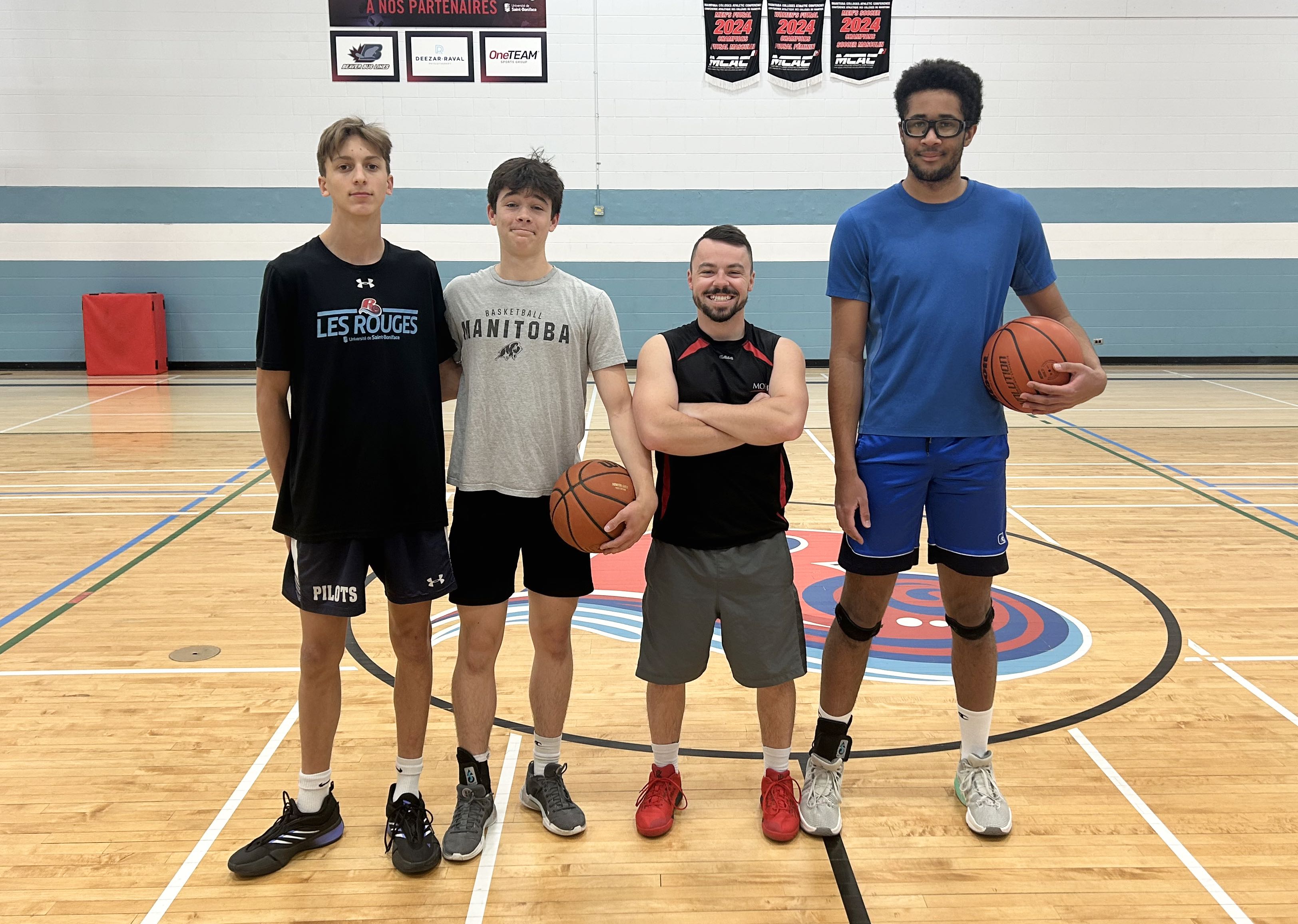 De gauche à droite : Yvan Turenne, Jack Sinnock, Matthew Trudeau (entraîneur de l’équipe masculine de basketball) et Tristan Gibbons. Joueurs absents de la photo : Félix Beaudry et
Osa Emokpae.