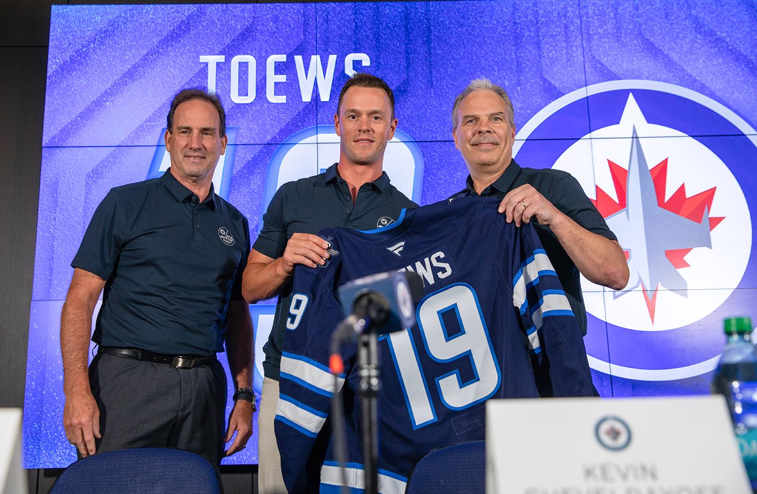 Jonathan Toews avec l'entraîneur-chef Scott Arniel et le directeur général Kevin Cheveldayoff.