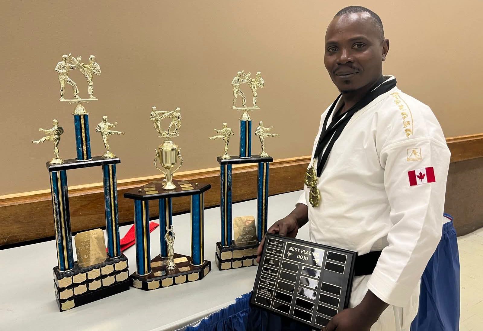 L'instructeur Hubert Kabasha avec la plaque du meilleur club performant de l'année.