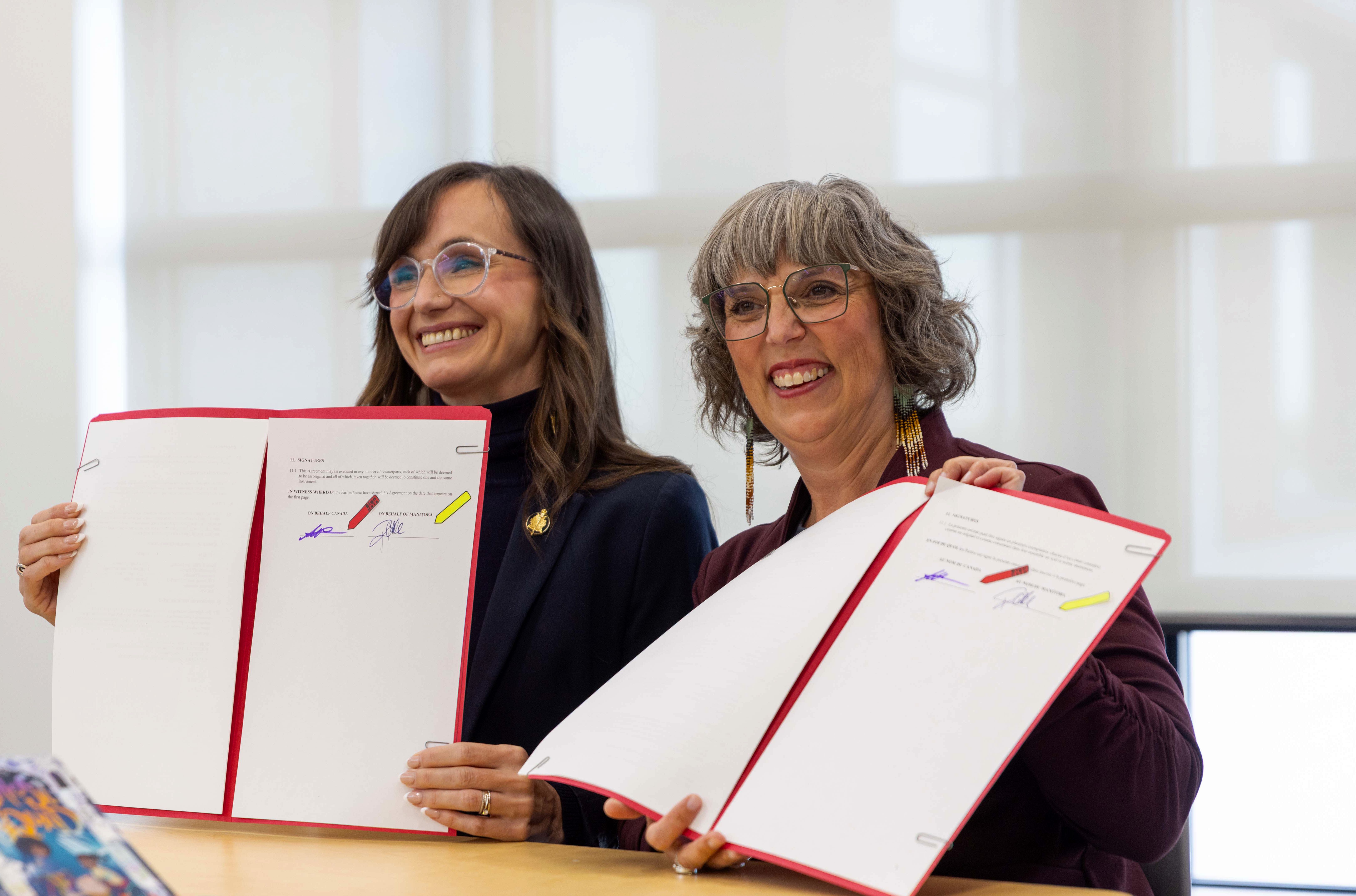 Renée Cable, ministre manitobaine de l’Éducation postsecondaire et de la Formation, et Ginette Lavack, députée fédérale de Saint-Boniface–Saint-Vital, en train de signer cette entente.