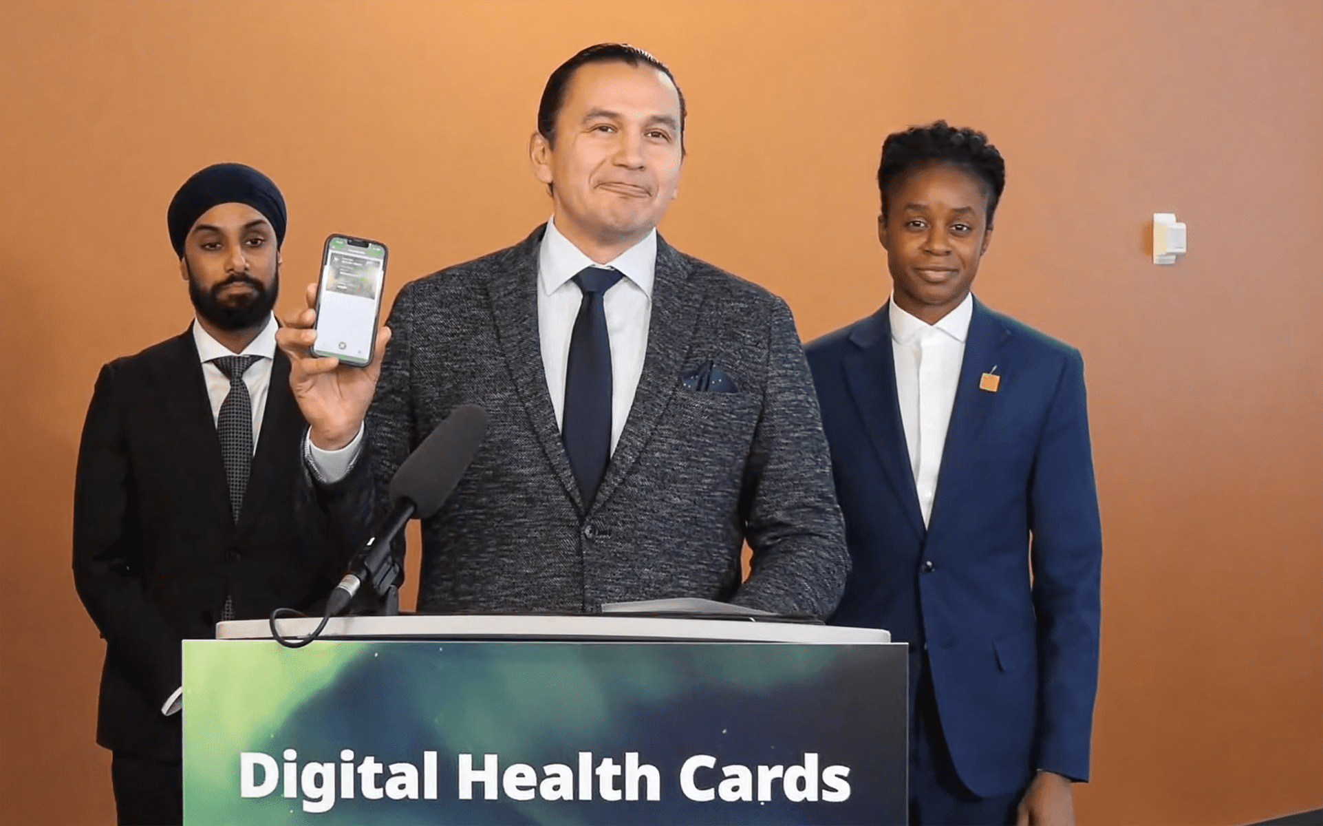 Wak Kinew, premier ministre du Manitoba, présente sa carte de santé directement sur son appareil mobile.