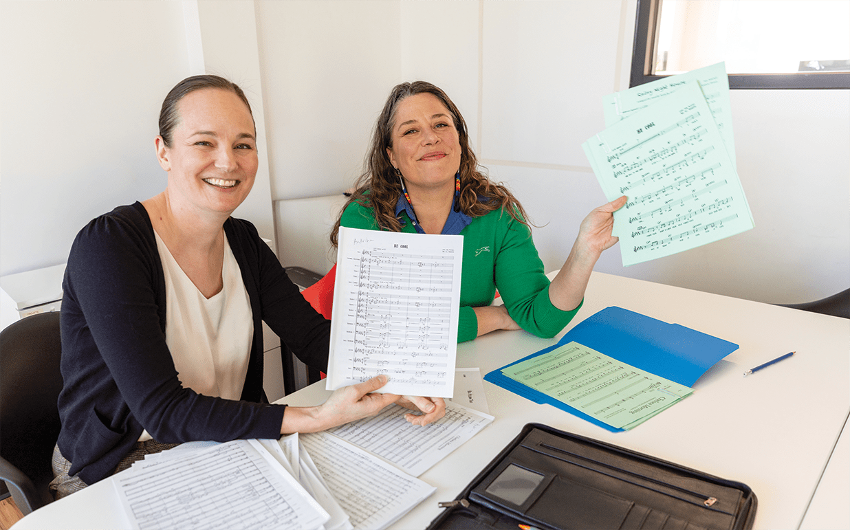 Alexis Silver (à gauche) et Andrina Turenne (à droite) posent avec quelques-unes des partitions pour le concert du 8 mars.