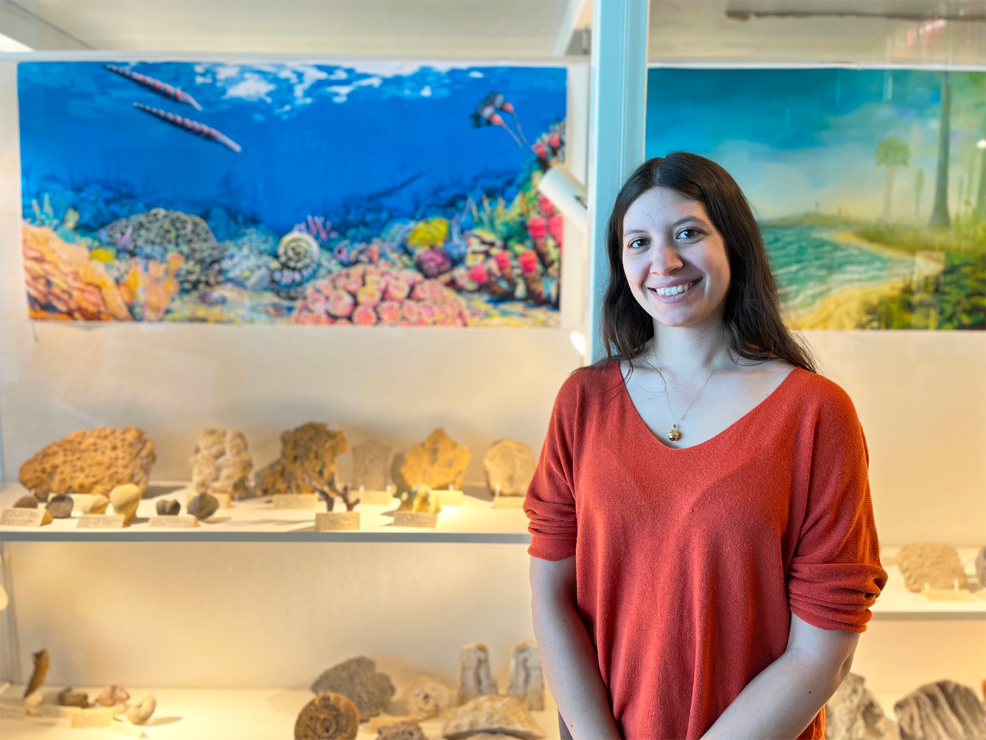 La Dre Melina Jobbins au Cretaceous Menagerie de l’Université de Manitoba. Elle se trouve devant le meuble dédié à la période de l'Ordovicien-Silurien.