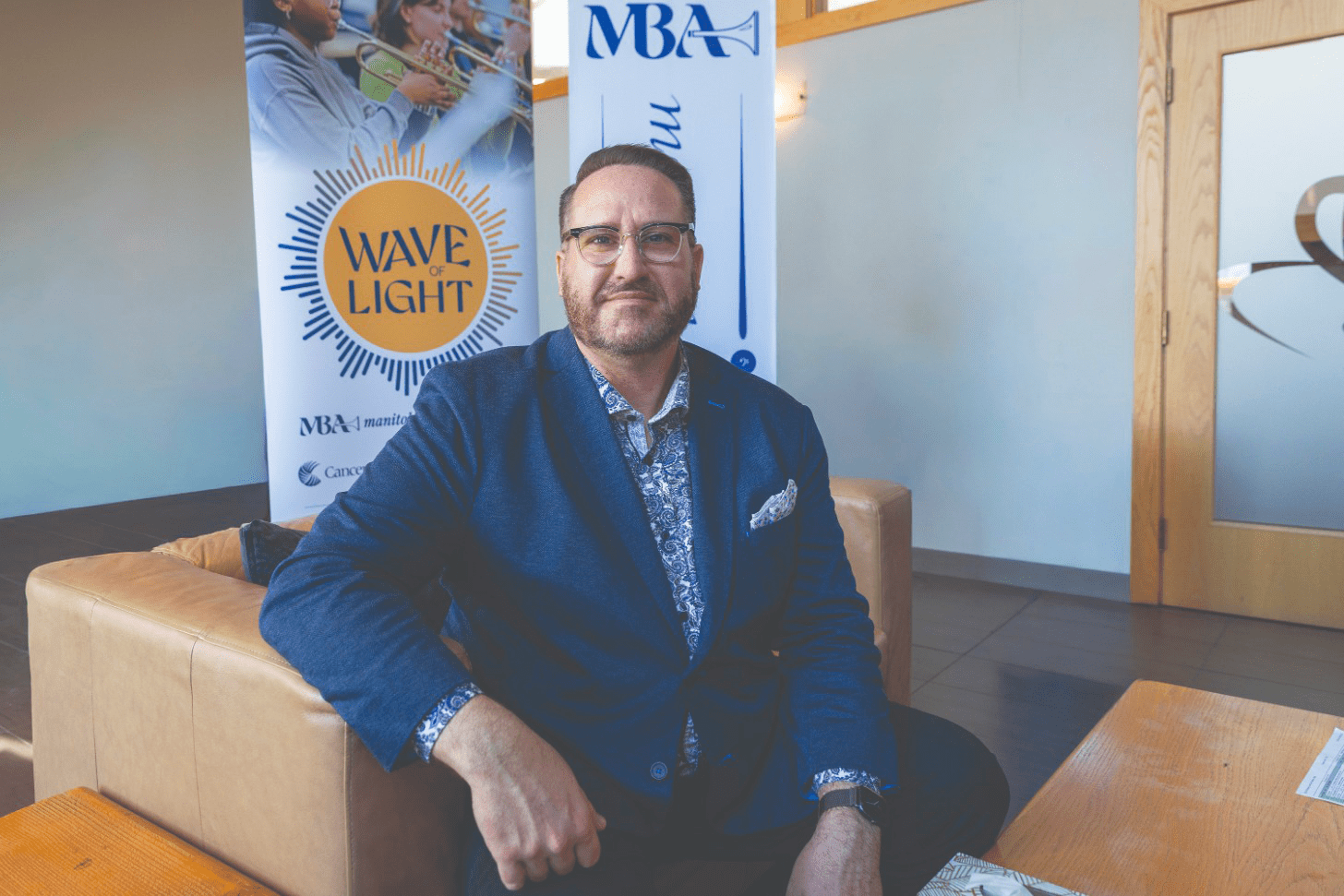 Brent Johnson, le directeur général de la Manitoba Band Association, avec les affiches de l’organisme et de Wave of Light en arrière.