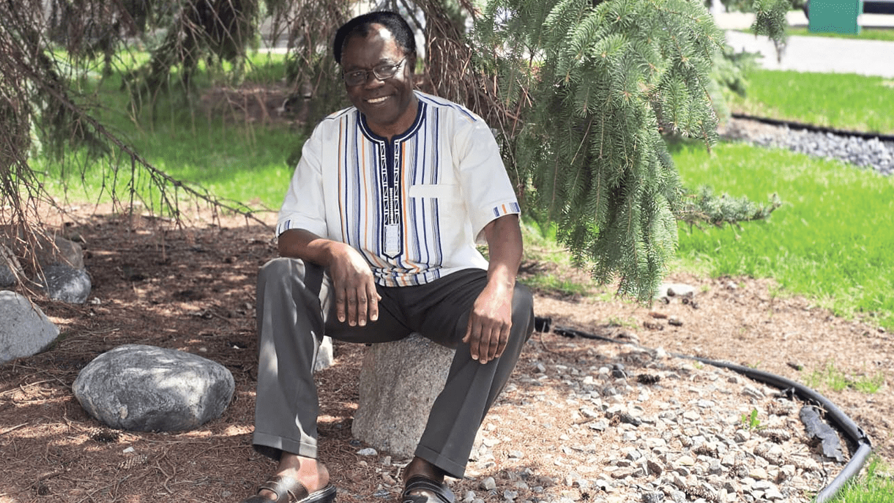 Faute de baobab, René Tondji-Simen, président de Sous le Baobab et de l’ACOMI, pose sous un conifère.