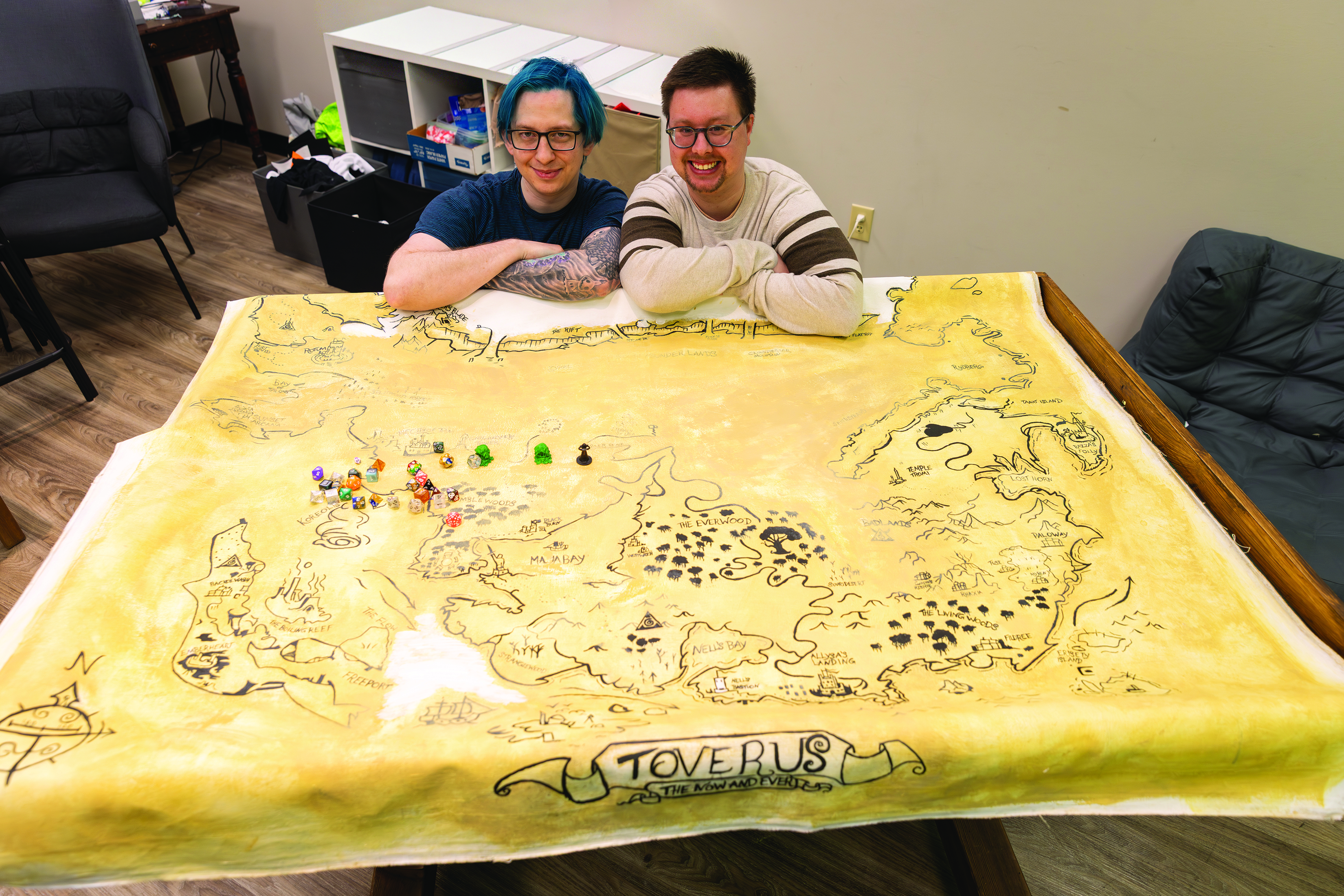 Thomas Wardell (à gauche) et Charlie Dilk (à droite) avec la carte du monde, les dés et les figurines utilisés dans les jeux de Donjons et Dragons chez PlayWell Therapy. (Photo : Marta Guerrero)