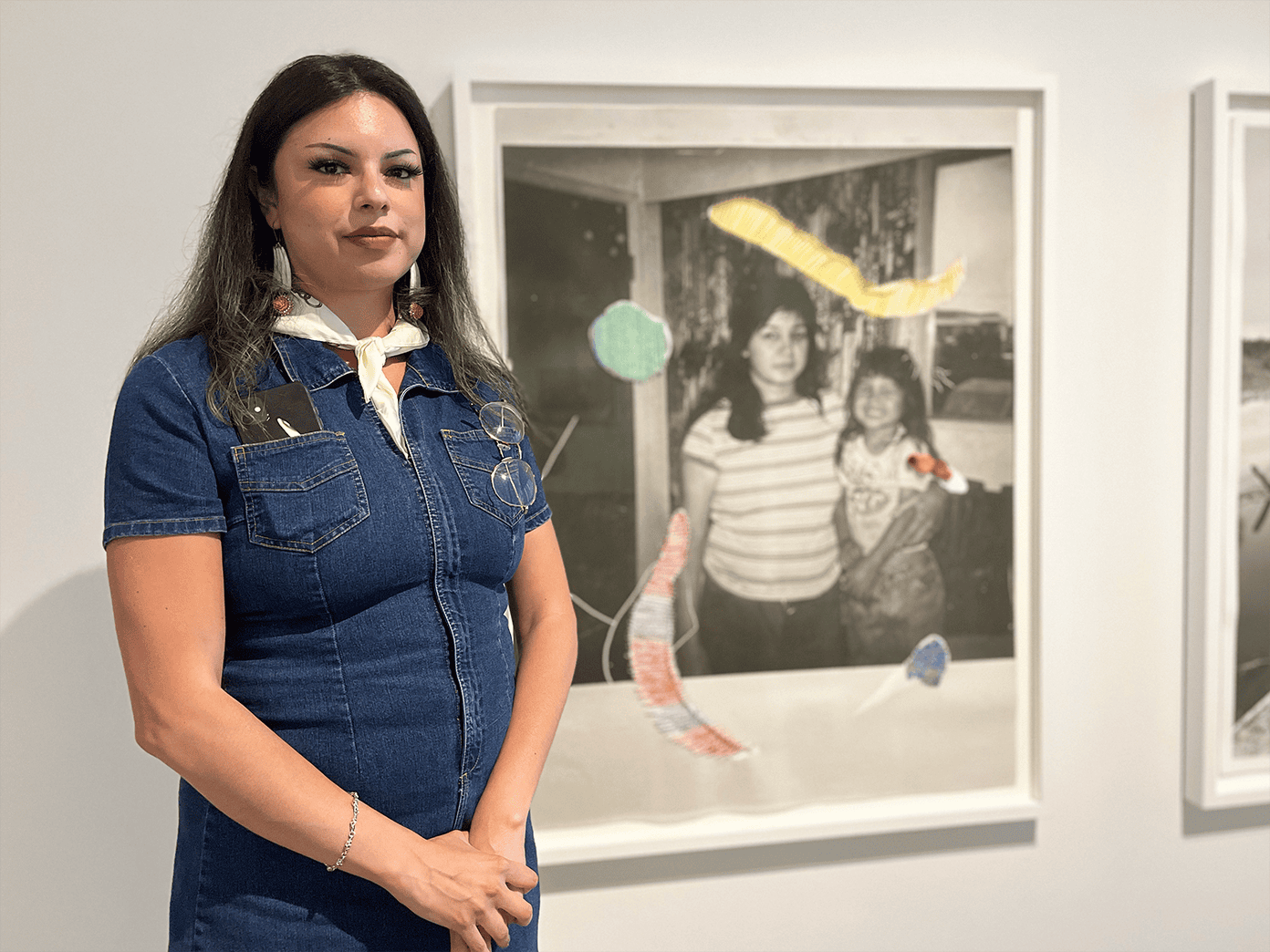 Marie-Anne Redhead, la conservatrice adjointe de l’art autochtone et contemporain au Musée des beaux-arts de Winnipeg. On la voit ici avec l’une des deux photos de Mother Land, réalisée par l’artiste Michelle Sound.