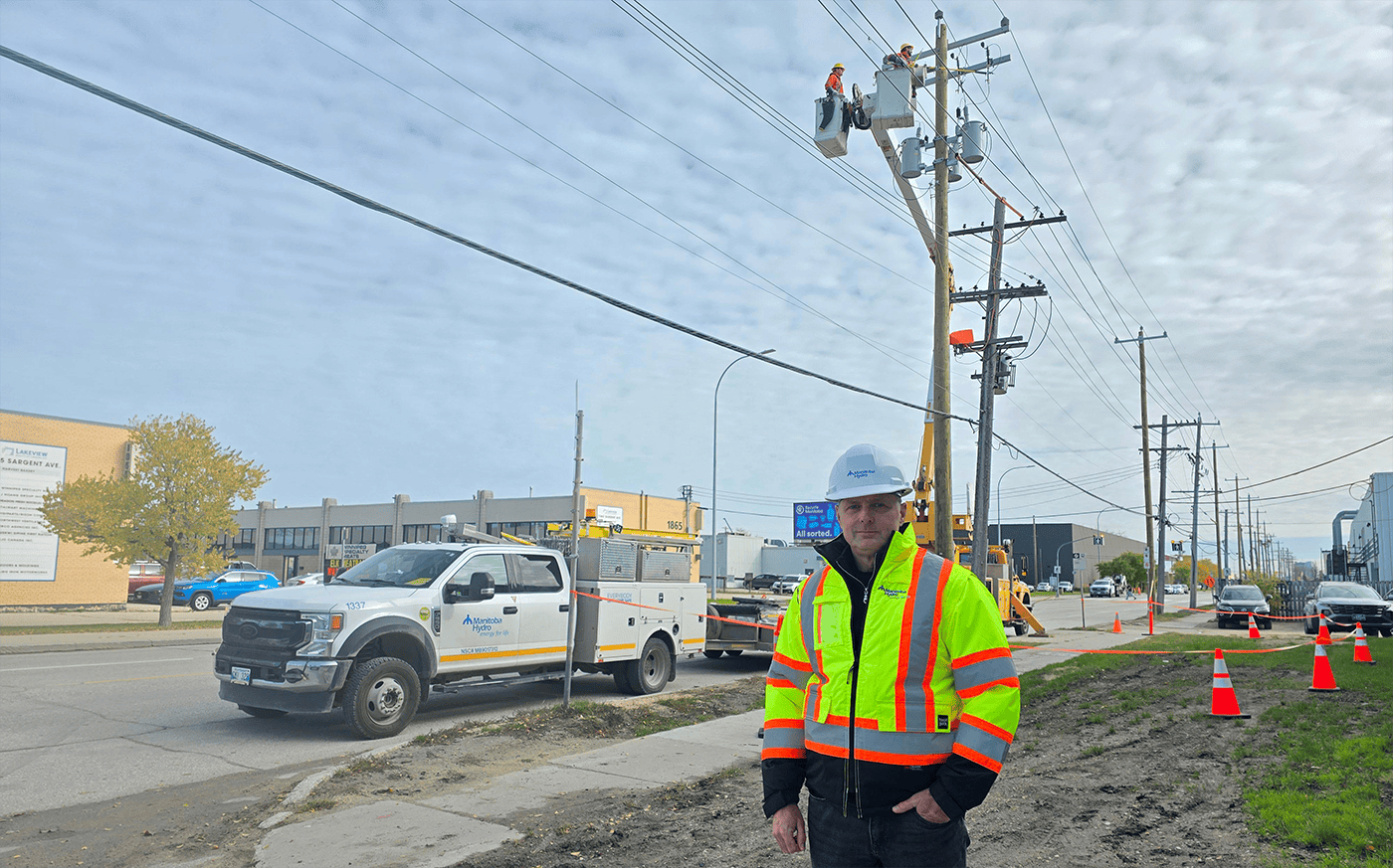 Derrière Peter Chura, avenue Sargent, des employés remplacent un poteau pour adapter le réseau à la tension plus élevée du poste Madison, qui prendra le relais du poste Berry.